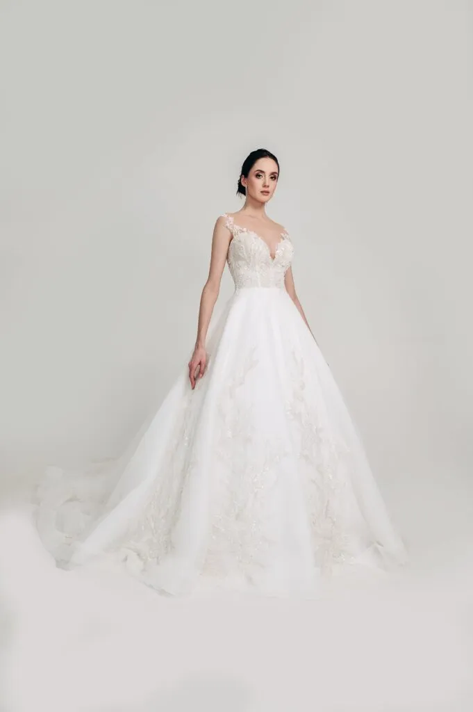 ---Dress for the classic and sophisticated bride with V-neckline and thin straps, made of satin and tulle embellished with lace 